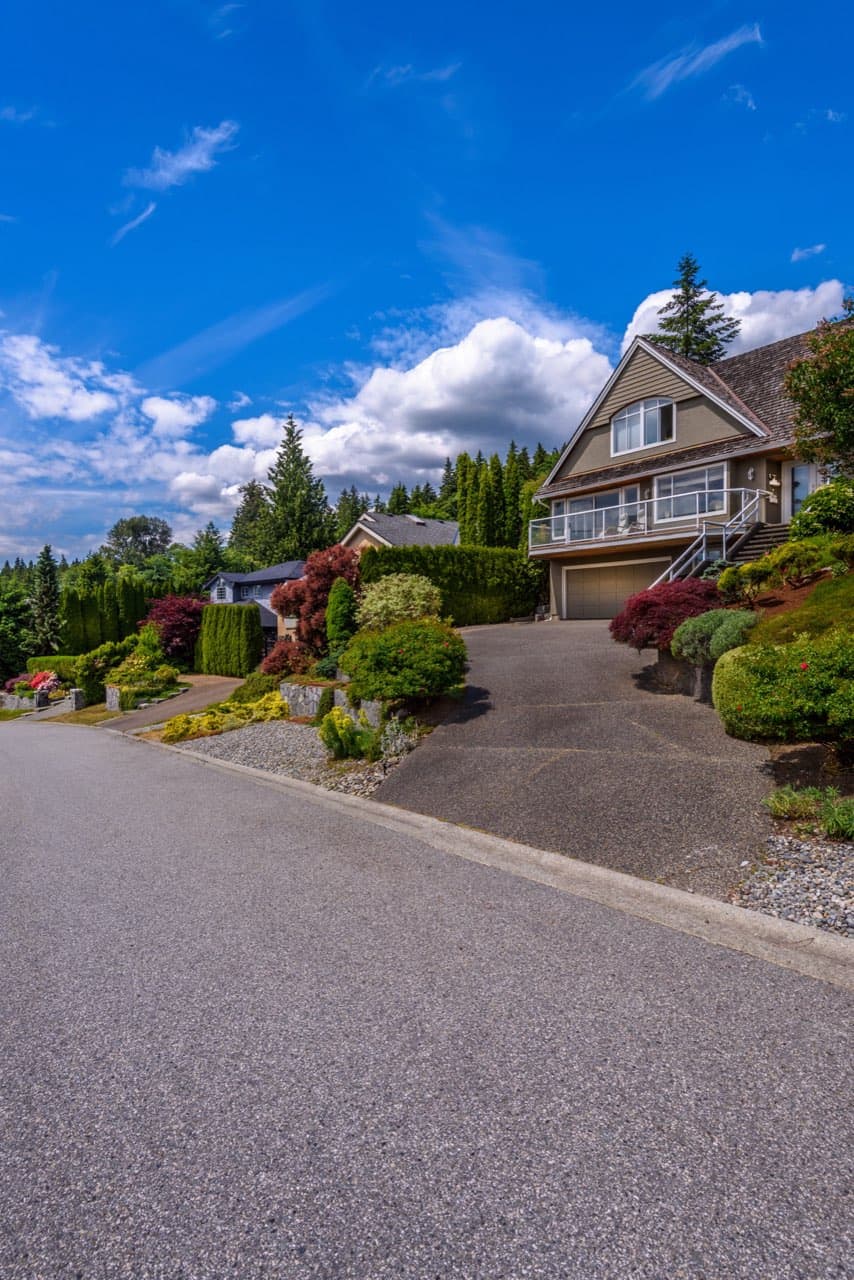 Newly paved black asphalt driveway in a suburban neighborhood