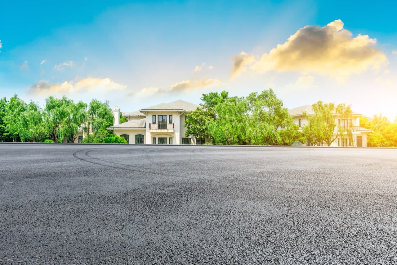 Empty commercial parking lot with smooth black asphalt at sunset
